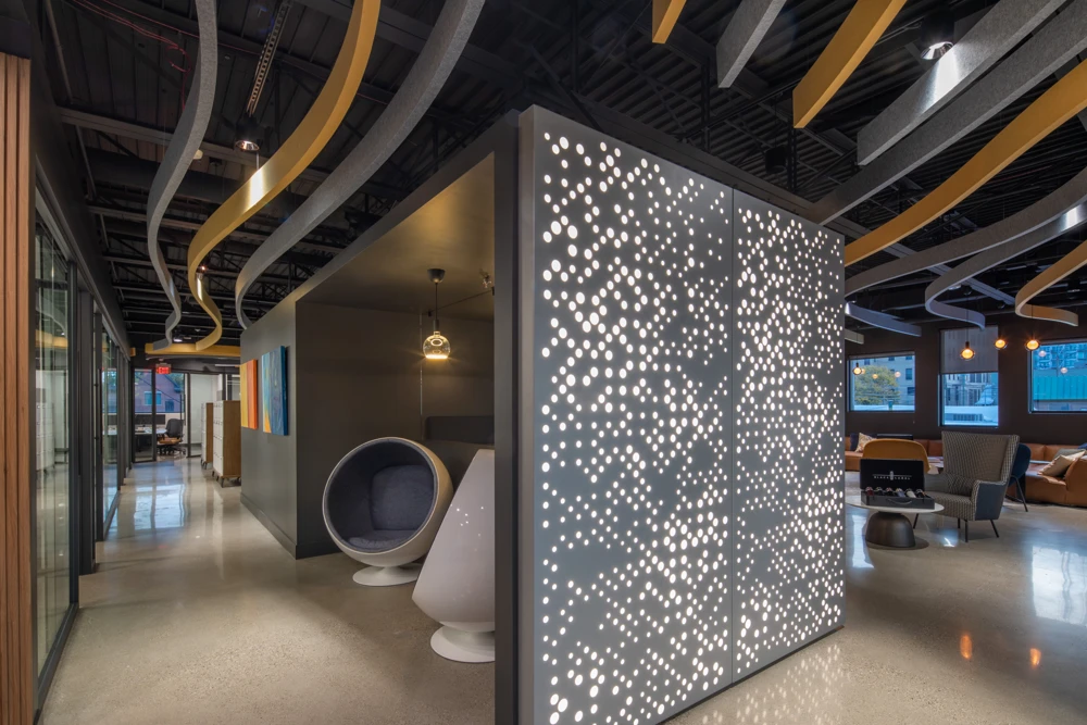 An illuminated perforated screen beneath the sculptural ceiling at K5 Headquarters
