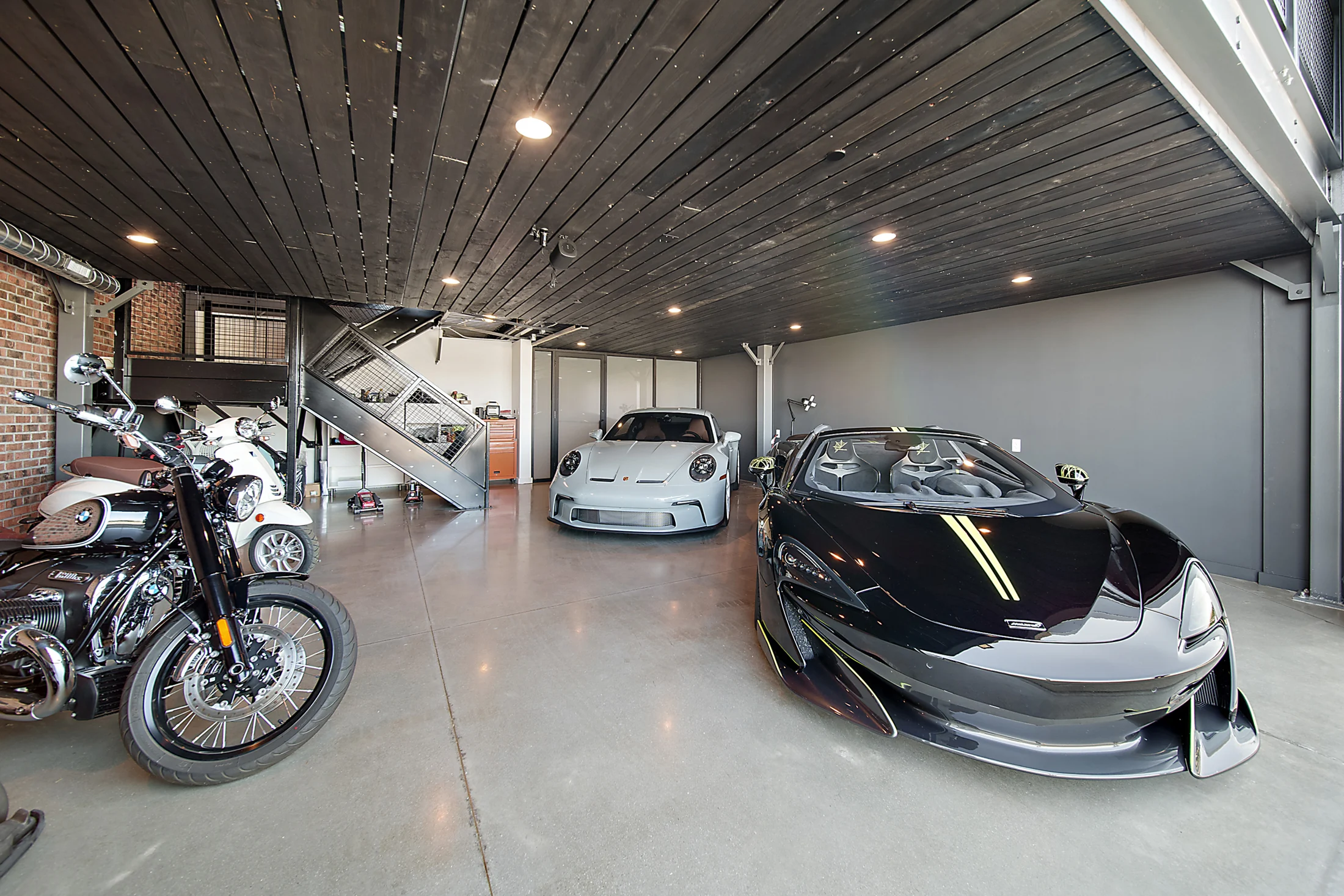 Cars and motorcycles beneath the custom mezzanine at Unit 172