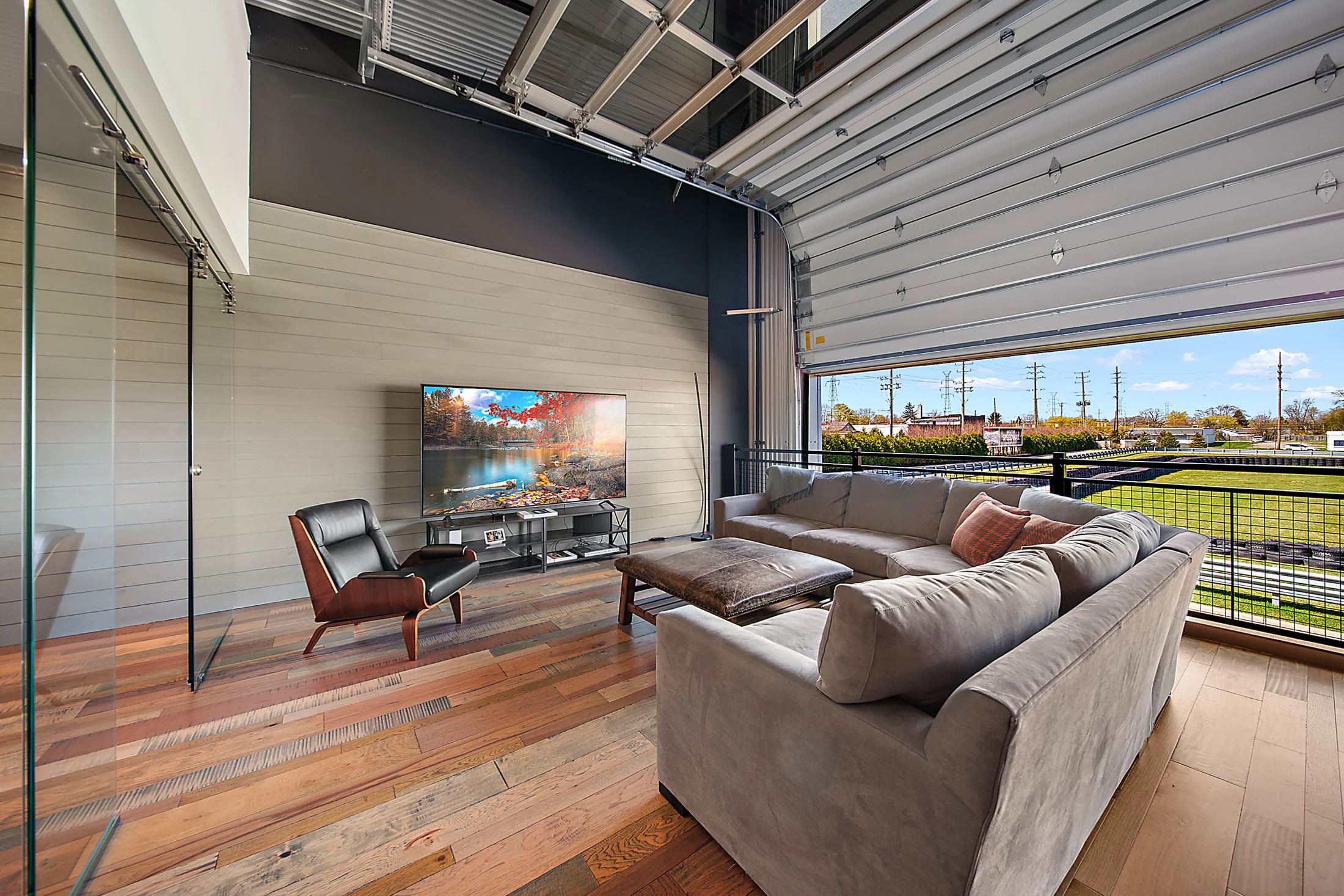 The upstairs lounge at Unit 172, with warm timber flooring and an open door toward the track