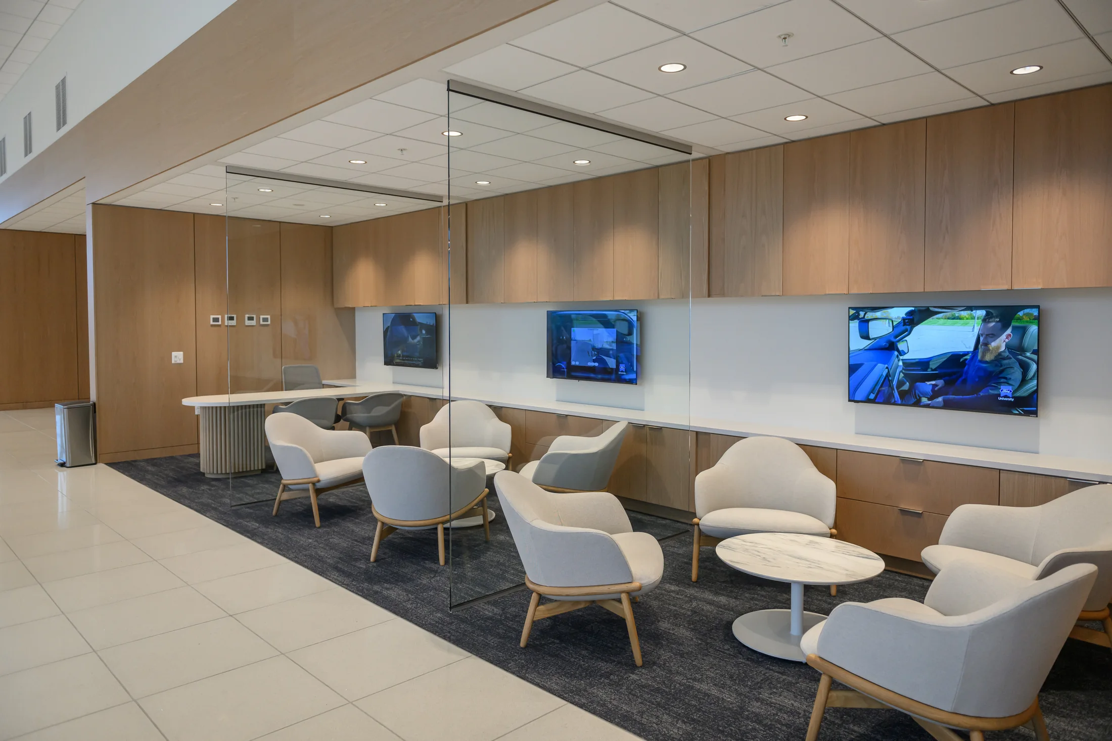 Customer seating, media and daylight form one connected setting.