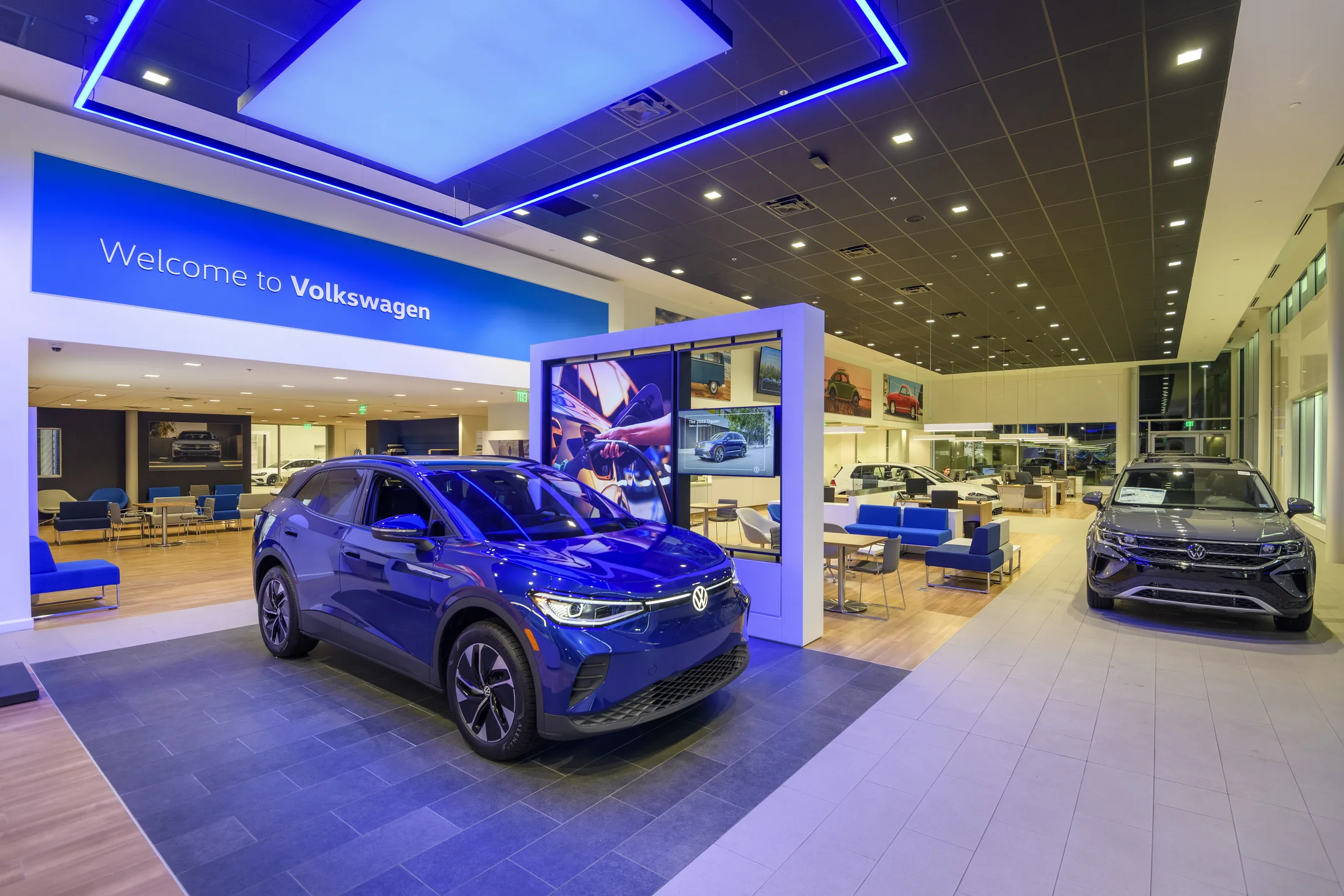 Contemporary display frames, lighting and vehicles share one showroom.